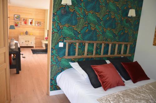 Un dormitorio con una cama con una pared verde. en Les terrasses de l'artiste, en Bazenville
