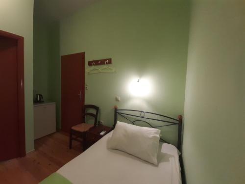 a green bedroom with a bed with a white pillow at Christina Guest House in Mystras