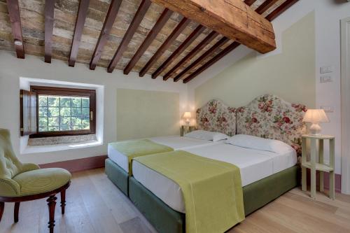 a bedroom with a bed and a chair and a window at Rambaldi Apartments Casa nr 2 in Bardolino