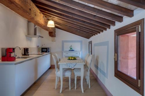 a kitchen and dining room with a table and chairs at Rambaldi Apartments Casa nr 2 in Bardolino