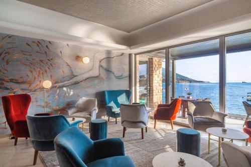 a room with chairs and tables and a wall of windows at Hotel Val Di Sogno - Adults Only in Malcesine