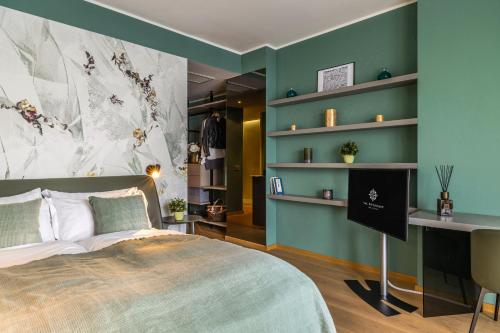 a bedroom with green walls and a bed with a desk at Hotel Val Di Sogno - Adults Only in Malcesine