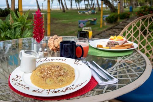 un tavolo di vetro con un piatto di cibo sopra di Alma del Pacifico Hotel & Spa a Esterillos Este