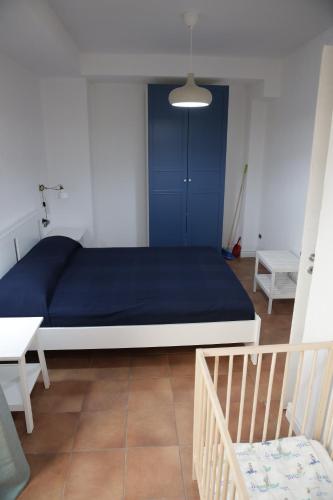 a bedroom with a large blue bed and a staircase at LA RAJA in Scilla