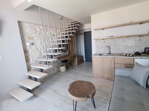 a living room with a spiral staircase and a table at Kali Thea Suites in Neos Marmaras