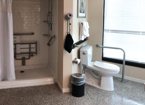 a bathroom with a toilet and a shower at Fort Pontchartrain Detroit, a Wyndham Hotel in Detroit