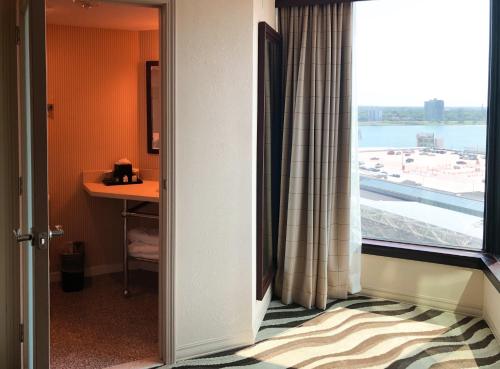 a room with a window with a view of an airport at Fort Pontchartrain Detroit, a Wyndham Hotel in Detroit