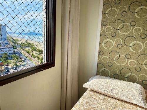 1 dormitorio con ventana y vistas a la playa en Residencial João Orisaka, en Samaritá