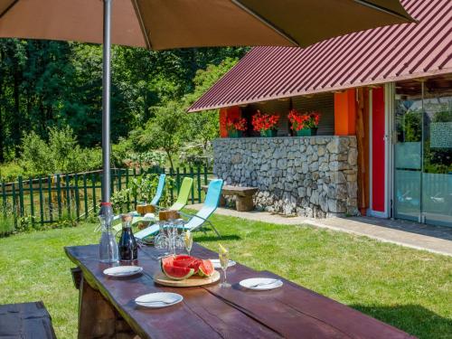 a wooden table with an umbrella and some chairs at Holiday Home Maja by Interhome in Lič