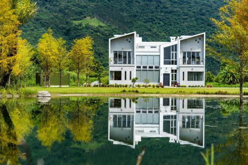una casa con un reflejo en un lago en 靜樹湖民宿Jing Shuhu B&B, en Shuhu
