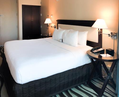 a bed in a hotel room with a phone on a table at Fort Pontchartrain Detroit, a Wyndham Hotel in Detroit