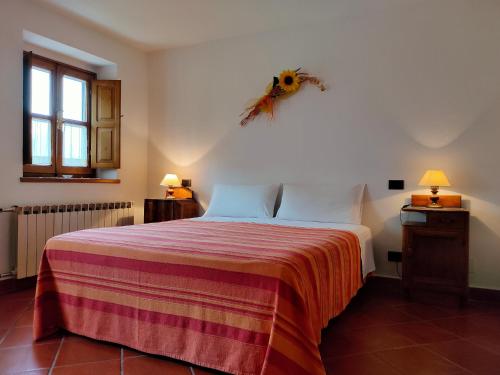 a bedroom with a bed with a red and white blanket at Il Girasole in Fosdinovo