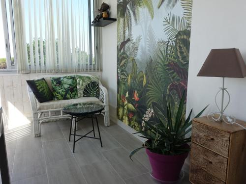 a living room with a chair and a table and a plant at Apartment Estany by Interhome in Le Barcarès