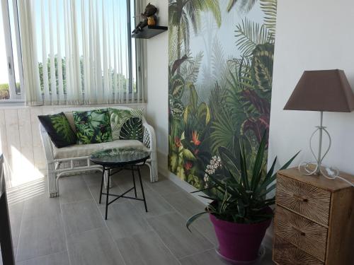 un salon avec une chaise, une table et une plante dans l'établissement Apartment Estany by Interhome, au Barcarès