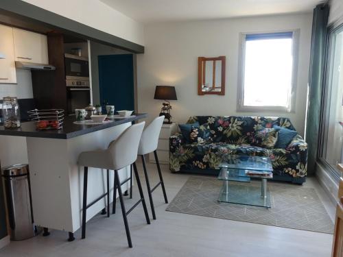 eine Küche und ein Wohnzimmer mit einem Sofa und einem Tisch in der Unterkunft Apartment Estany by Interhome in Le Barcarès
