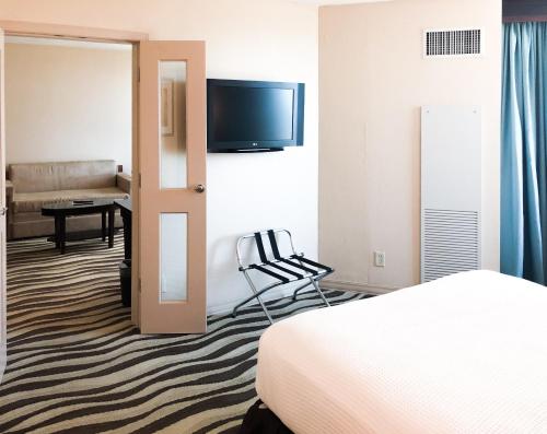 a hotel room with a bed and a television at Fort Pontchartrain Detroit, a Wyndham Hotel in Detroit
