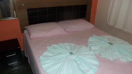 a bed with two pillows on it in a room at Pousada da Lenna in Rio das Ostras