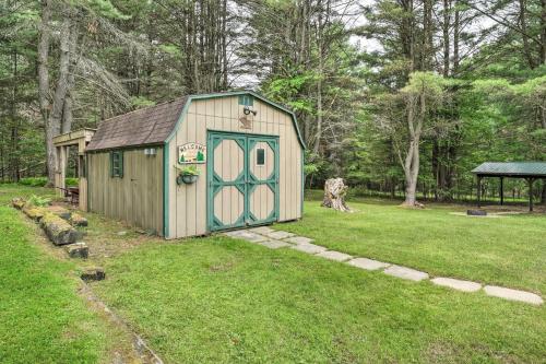 a small shed with a green door in a yard at Deck, Fire Pit and Yard Mountain Escape! in Benezette