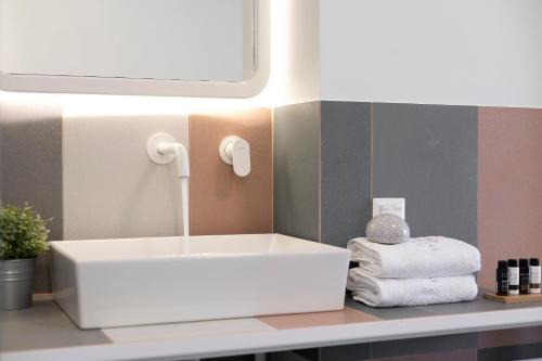 a bathroom with a white sink on a counter at Mandraki Village Boutique Hotel in Koukounaries