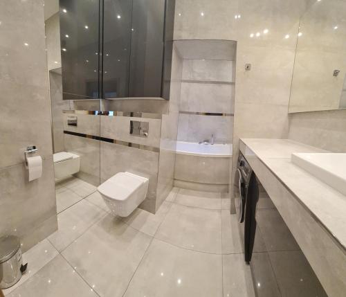 a bathroom with a toilet and a sink and a tub at Apartament dwupoziomowy Kłodzko - Centrum in Kłodzko