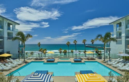 a pool with chairs and the ocean in the background at The Seabird Ocean Resort & Spa, Part of Destination Hotel by Hyatt in Oceanside