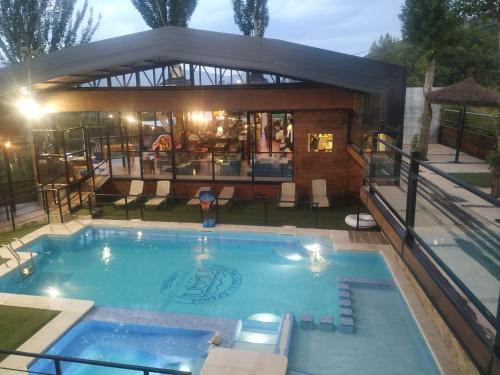 a swimming pool in front of a house at Posada Rural SPA Granja LA TEJERA de Lozoya in Gargantilla del Lozoya