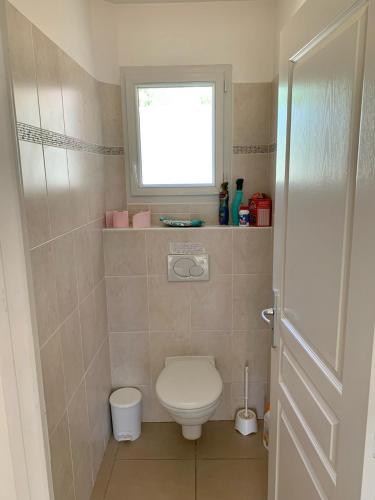 Elle comprend une petite salle de bains pourvue de toilettes et d'une fenêtre. dans l'établissement Grande maison vue sur lac à Pelleautier très calme, à Pelleautier