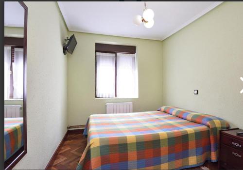 Pensión Minibar في Zarátamo: غرفة نوم صغيرة مع سرير ومرآة