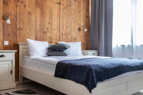 a bedroom with a bed with a blue blanket at Airport Wanderer Inn - Vándor fogadó in Vecsés
