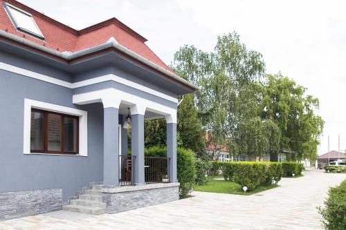 a blue house with a red roof at Airport Wanderer Inn - Vándor fogadó in Vecsés