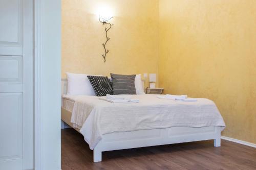 a bedroom with a white bed and a yellow wall at Airport Wanderer Inn - Vándor fogadó in Vecsés