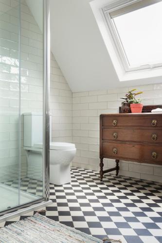a bathroom with a toilet and a dresser and a window at Bridge Street Townhouse in Kenmare