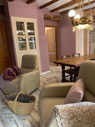 a living room with two chairs and a table with a basket at La Caseta del Priorat in Porrera