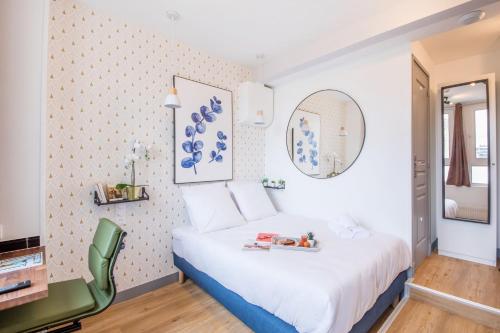 une chambre avec un lit blanc et une chaise verte dans l'établissement WS Jardin du Luxembourg - Boissonade, à Paris