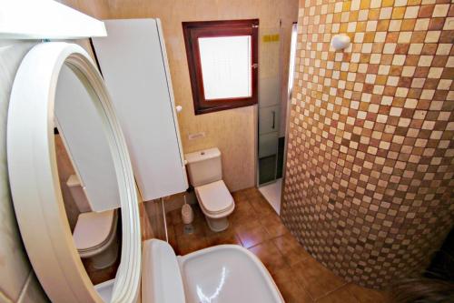 uma casa de banho com um WC, um lavatório e um espelho. em Basetes - holiday home with private swimming pool in Calpe em Calpe