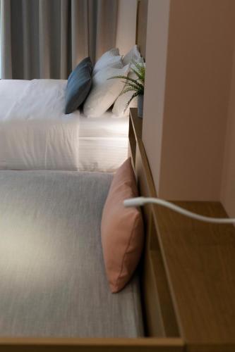 a bedroom with two beds and a dresser with a pillow at Mandraki Village Boutique Hotel in Koukounaries