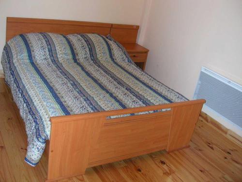 a bed with a wooden frame in a bedroom at Résidence Gavarnie in Gèdre