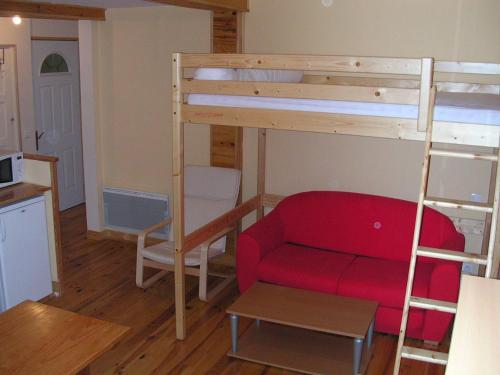 ein Wohnzimmer mit einem Etagenbett und einem roten Sofa in der Unterkunft Résidence Gavarnie in Gèdre