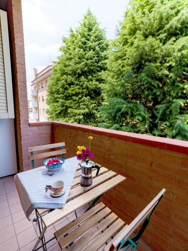 a wooden table and bench on a balcony with trees at Burò il Viaggiatore in Parma