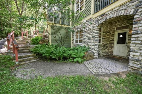 a stone house with a staircase leading to a door at Tremblant Les Eaux by Rendez-Vous Mont-Tremblant in Mont-Tremblant