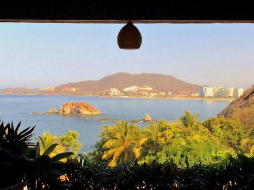 a view of the ocean from a window at Vista de las Rocas in Ixtapa