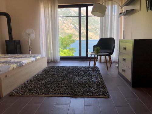 - une chambre avec un lit, une chaise et une fenêtre dans l'établissement Villa Arina, à Kotor