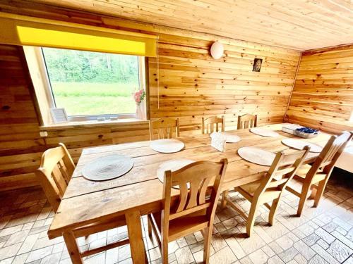 a wooden dining room with a wooden table and chairs at Guest House Gravas in Bauska