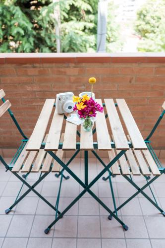 a picnic table with a camera and flowers on it at Burò il Viaggiatore in Parma