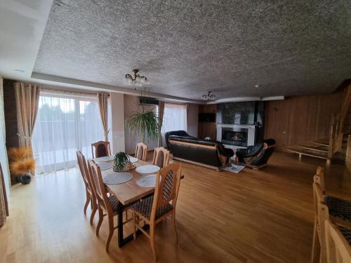 a living room with a table and a couch at Villa MAG in Druskininkai