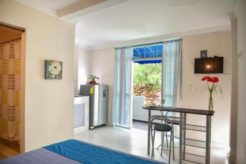 a living room with a table and a kitchen at Perth House Taganga in Taganga