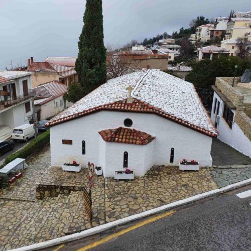 a small white church with a tiled roof at Epic Rooms in Delfoi