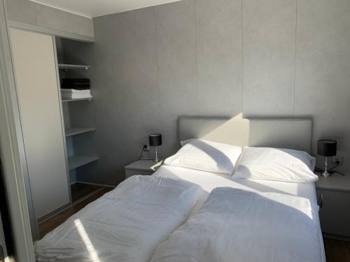 een slaapkamer met een bed met witte lakens en een raam bij Doelweg 35 Chalet 172 - No Companies in Goedereede