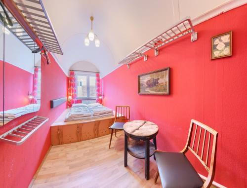 una camera con pareti rosse e tavolo e sedie di Labyrinth Hostel Weimar a Weimar