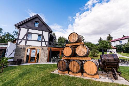 a stack of wine barrels in front of a house at Apartmány Sklepy Mařatice in Uherské Hradiště